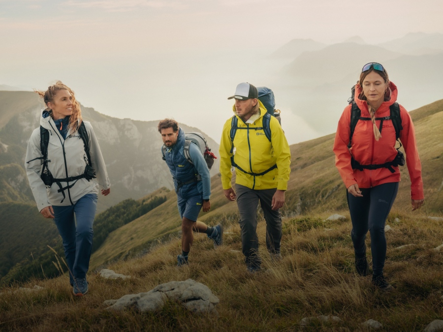 Four people hiking in a misty mountainous landscape